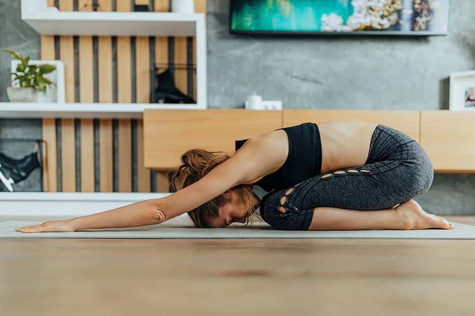 Slim woman doing gymnastics at home.