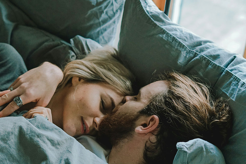 a couple cuddling in bed